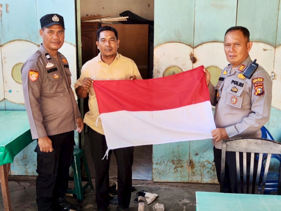 Polisi Bagikan Bendera Merah Putih ke Warga Bangko Pusako Jelang HUT RI ke-81